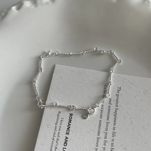Détail macro du bracelet en argent sterling S925 avec nœud torsadé sur plateau