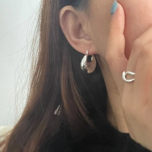 Gros plan détaillé de boucles d'oreilles créoles en argent et bague nœud sur un mannequin