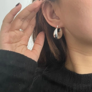 Gros plan de boucles d'oreilles créoles en argent poli avec finition miroir lisse