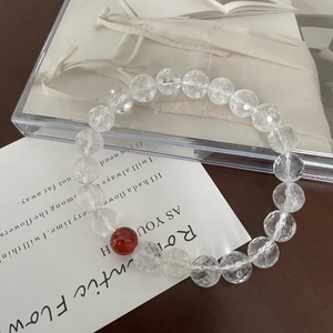 Faceted clear quartz beaded bracelet with a single red agate stone on poetic card