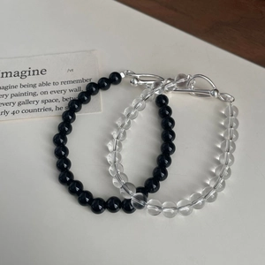 Detailed close-up of beaded bracelets with silver infinity clasp and black agate beads