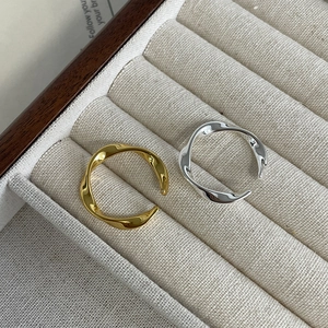 Nahaufnahme von verstellbaren Ringen in Gold und Silber mit Wellentextur in Box