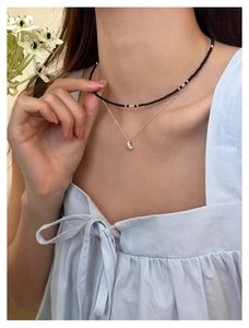 Détail du collier double couche en argent S925 avec perles noires et pendentif croissant
