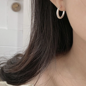Close-up of minimalist S925 sterling silver hoop earrings with a matte brushed texture