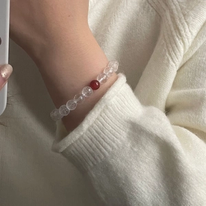 Chic white cracked crystal beaded bracelet with a single red agate bead on a model