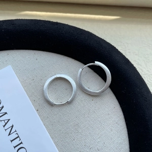 Close-up of S925 silver hoop earrings with a matte brushed texture and minimalist design