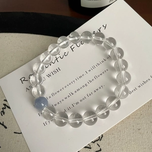 Bracelet minimaliste en aigue-marine et cristal de roche sur une carte blanche