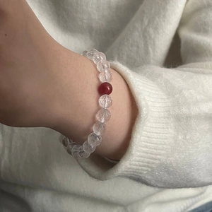 Macro view of crystal beaded bracelet with faceted clear stones and red agate bead