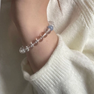 Détail du bracelet en aigue-marine et perles de cristal sur mannequin en tricot blanc