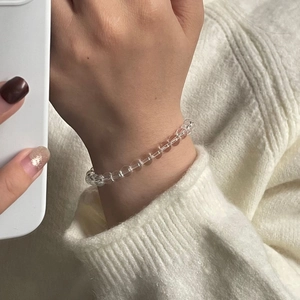 Close-up of a minimalist clear crystal beaded bracelet on a woman's wrist