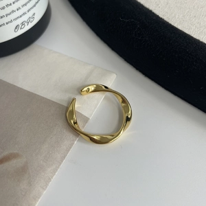 Nahaufnahme der goldenen Wellenstruktur und der verstellbaren Ringschiene eines Rings