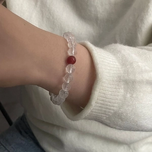 Detailed view of faceted white crystal beads and red agate on a minimalist beaded bracelet