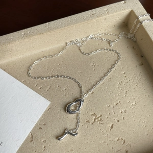 Detail der S925 Silberkette mit flüssigem Wassertropfen-Anhänger auf Steintablett