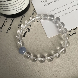 Détail du bracelet en cristal blanc avec pierre bleue sur un tissu en lin