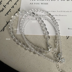 Detail view of 2mm, 4mm, and 6mm white crystal beads with silver heart pendant clasp