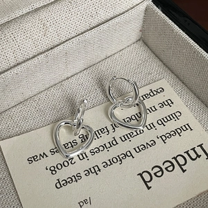 Elegant 925 sterling silver heart dangle hoop earrings on a vintage paper background