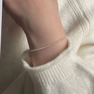 Detail of delicate clear crystal beaded bracelet on wrist with silver extension chain