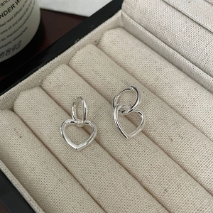 Detail of 925 sterling silver heart hoop earrings displayed in a beige velvet jewelry box