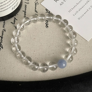 Vue détaillée d'un bracelet en cristal clair avec un accent bleu sur tissu de jute
