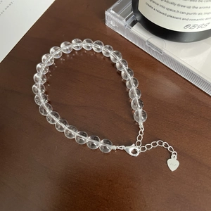 Detailed macro of S925 sterling silver lobster clasp and clear crystal beads on dark wood