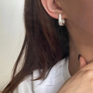 Nahaufnahme von minimalistischer S925 Silber-Ohrring mit gebürsteter Textur-Oberfläche