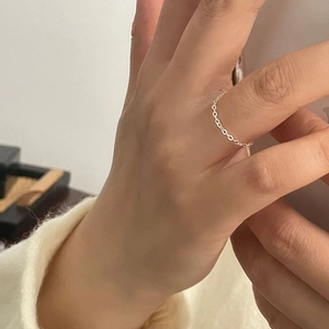 Gros plan d'une bague chaîne souple minimaliste en argent sterling S925 au doigt