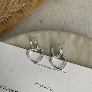 Detailed macro view of 925 sterling silver minimalist heart charm hoop earrings