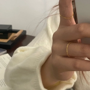 Macro d'anneaux minimalistes en chaîne d'argent 925 superposés sur les doigts féminins