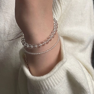 Detail of S925 silver beaded bracelet set with white crystal on a white knit sweater