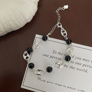 Detail of S925 sterling silver bracelet featuring black agate beads and heart pendant