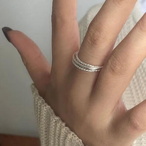 Close-up of S925 sterling silver multi-layered twist rope ring worn on finger