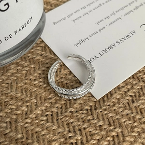 Detail of S925 sterling silver multilayer twisted ring on rustic linen background