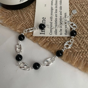 Detail of S925 sterling silver pig nose bracelet with black onyx beads and heart charm