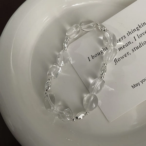 Minimalist S925 sterling silver bracelet with clear oval crystal beads on white ceramic tray