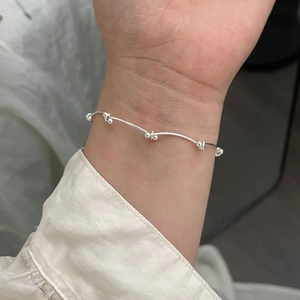 Gros plan d'un bracelet en argent sterling 925 perlé porté au poignet d'un mannequin