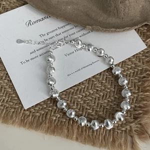 Detailed macro view of S925 sterling silver beaded bracelet with textured metal spheres
