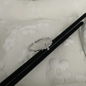 Macro detail of silver cross ring with cubic zirconia and geometric textured band