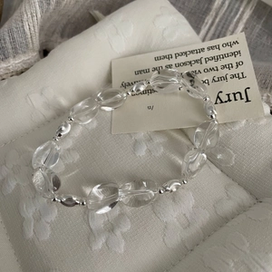 Close-up of white crystal beaded bracelet with S925 sterling silver beads on textured fabric