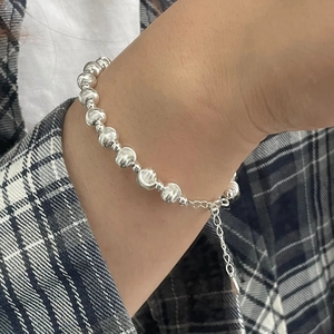 Detail of silver striped bead bracelet with lobster clasp and adjustable chain extender