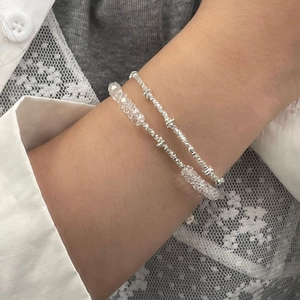 Detailansicht eines zweilagigen S925 Silberarmbands mit weißen Kristallperlen am Handgelenk