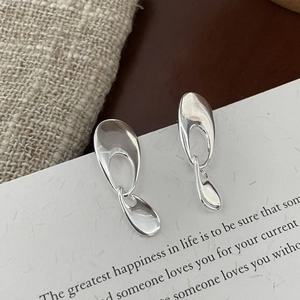 Detailed close-up of 925 sterling silver geometric drop earrings with fluid metal texture