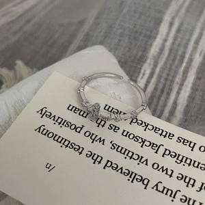 Macro detail of silver cross ring with cubic zirconia on adjustable bamboo-style band
