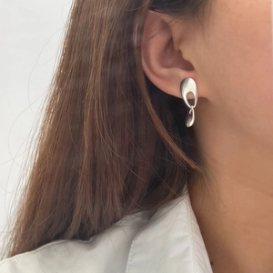 Macro shot of 925 sterling silver geometric earrings with a sleek mirror finish on model