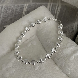Detailed view of silver bead bracelet featuring textured spheres and a lobster clasp closure