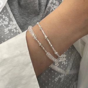 Detail von geschichteten S925 Silberperlen-Armbändern mit Kristallperlen am Handgelenk