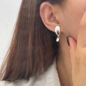 Macro shot of 925 sterling silver geometric hollow droplet earrings worn by model