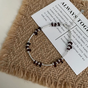 Detailed macro view of S925 sterling silver tube beads and garnet gemstone beaded bracelet