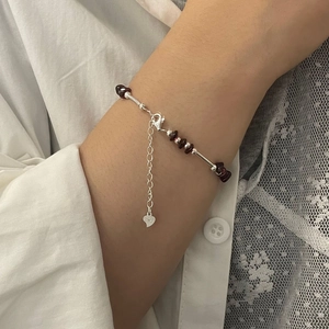 Detail of S925 sterling silver lobster clasp and heart tag on garnet beaded bracelet