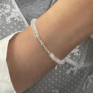 Nahaufnahme von S925 Sterling Silber Armband mit weißen Kristallperlen am Handgelenk