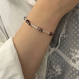 Detailed view of handmade S925 silver bracelet with garnet stone beads on a wrist